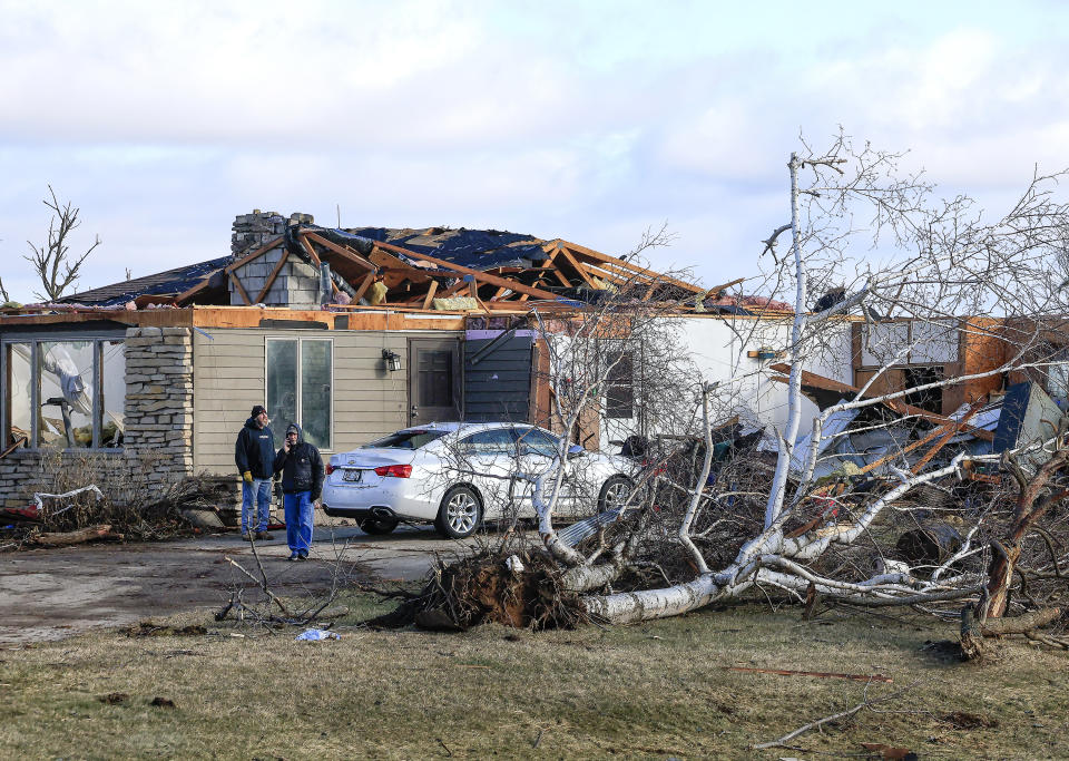 Family members and friends gather at the Rock County, Wis. home of Marilyn Kueng Friday, Feb. 9, 2024 after the property was damaged in a tornado the previous day. Kueng, 83, who was on the first floor of the home when its roof was lifted off, was not injured in the storm. (John Hart/Wisconsin State Journal via AP)