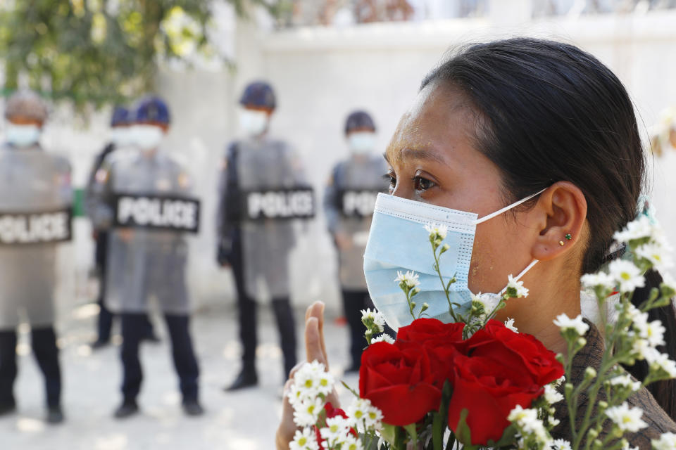 Una mujer hace un saludo de protesta con tres dedos de una mano en alto durante la comparecencia de cuatro activistas detenidos en un tribunal, en Mandalay, Myanmar, el 5 de febrero de 2021. (AP Foto)