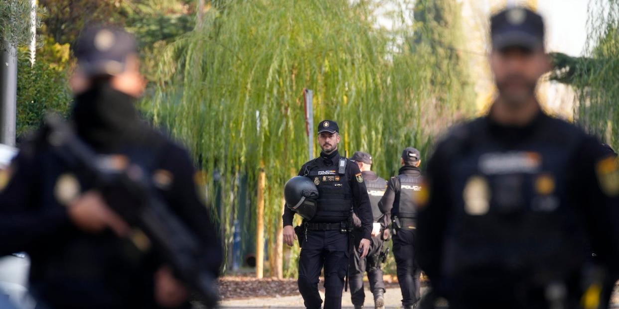 Police officers stand guard as they cordon off the area next to the Ukrainian embassy in Madrid, Spain, Wednesday, Nov. 30, 2022.