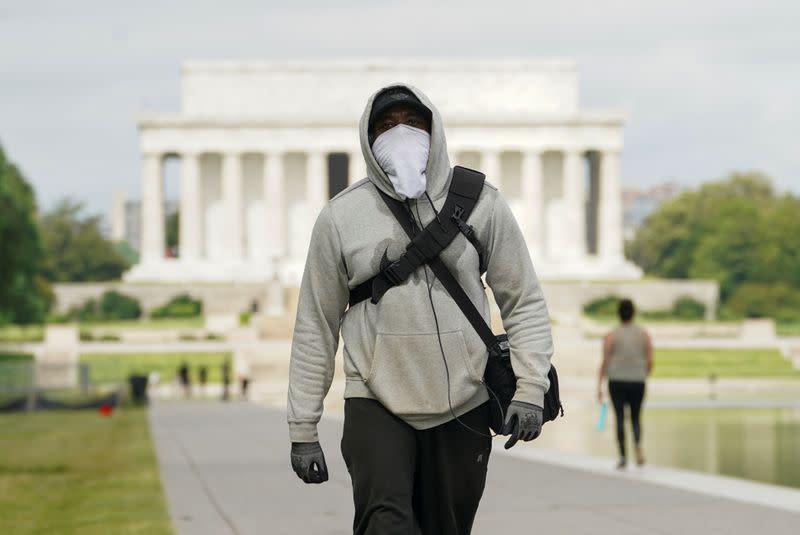 A man wears face mask and gloves while walking the National Mall during the coronavirus disease (COVID-19) pandemic in Washington