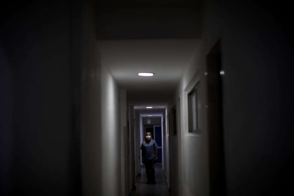 Nurse Lidia Del Valle walks inside the San Andres Clinic which has been occupied by its former workers since it closed at the start of the year following the death of the hospital's director and owner in Caseros, Argentina, Friday, April 30, 2021. While the pandemic has swelled the need for hospital beds, many private clinics say they're struggling to survive, citing the pandemic having pushed away many non-COVID patients and losing money on coronavirus sufferers because the government insurance program doesn't pay enough to meet costs. (AP Photo/Natacha Pisarenko)