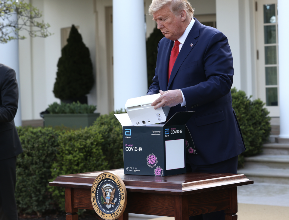 U.S. President Donald Trump takes a new COVID-19 test kit developed by Abbott Labs out of its box during the daily coronavirus briefing at the Rose Garden of the White House on March 30, 2020 in Washington, DC. (Photo: Win McNamee/Getty Images) 