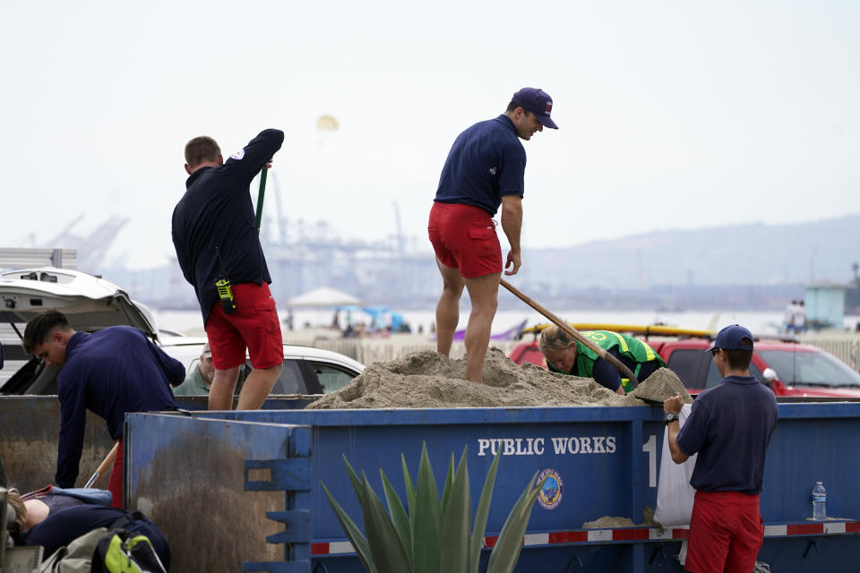 Long Beach lifeguards fill up sandbags for residents ahead of Hurricane Hilary, in Long Beach, Calif., Saturday, Aug. 19, 2023. (AP Photo/Damian Dovarganes)