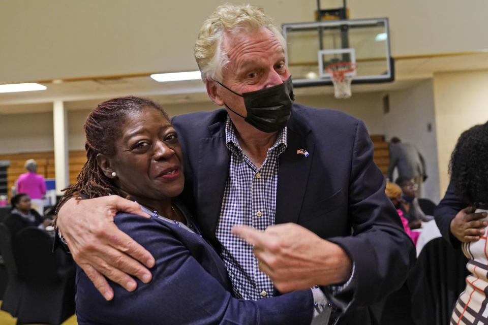 Democratic gubernatorial candidate, former Gov. Terry McAuliffe, right, hugs a supporter during a rally in Richmond, Va., Thursday, Oct. 28, 2021. McAuliffe will face Republican Glenn Youngkin in the November election. (AP Photo/Steve Helber)
