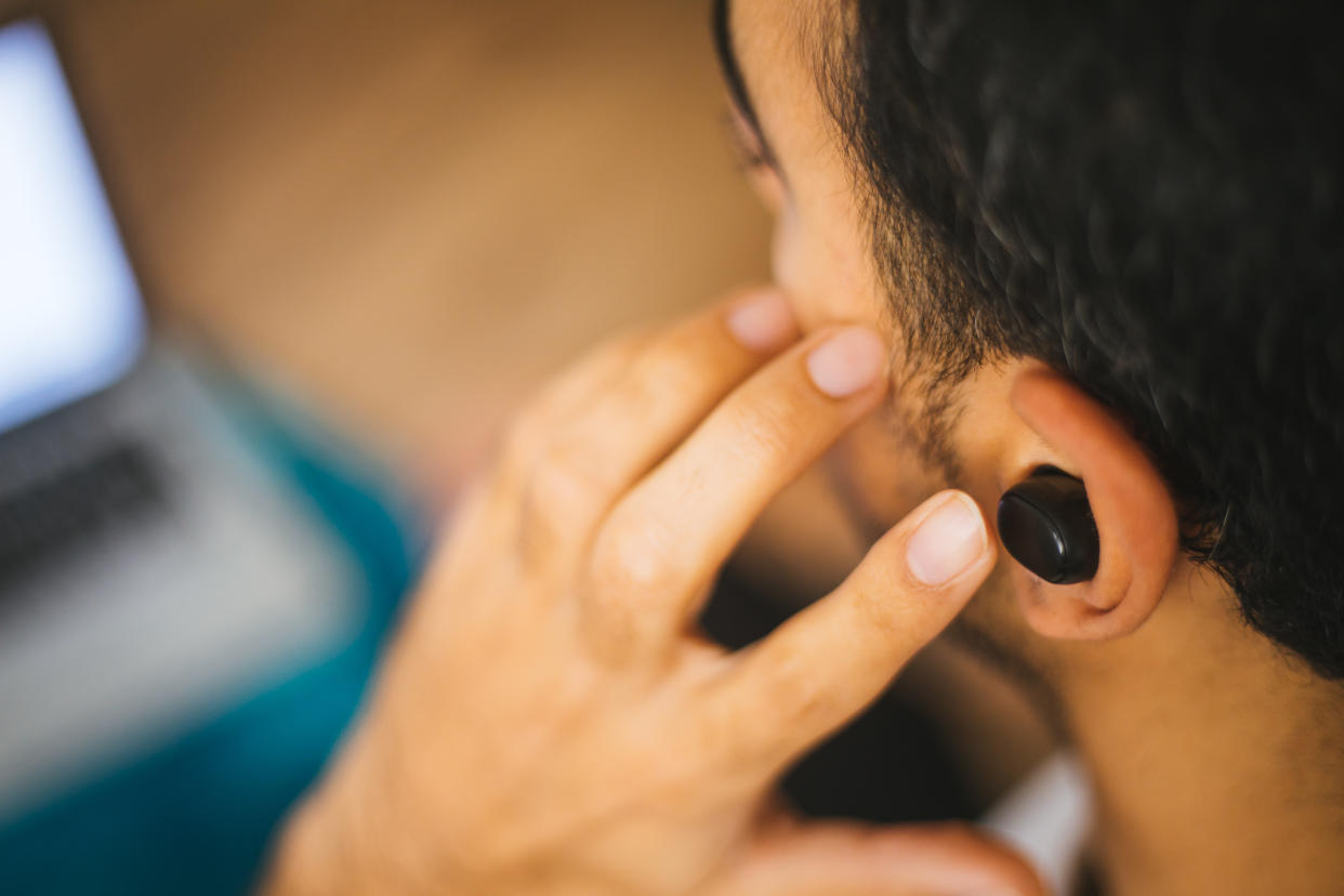 Man holding air pods headphones in hands close-up