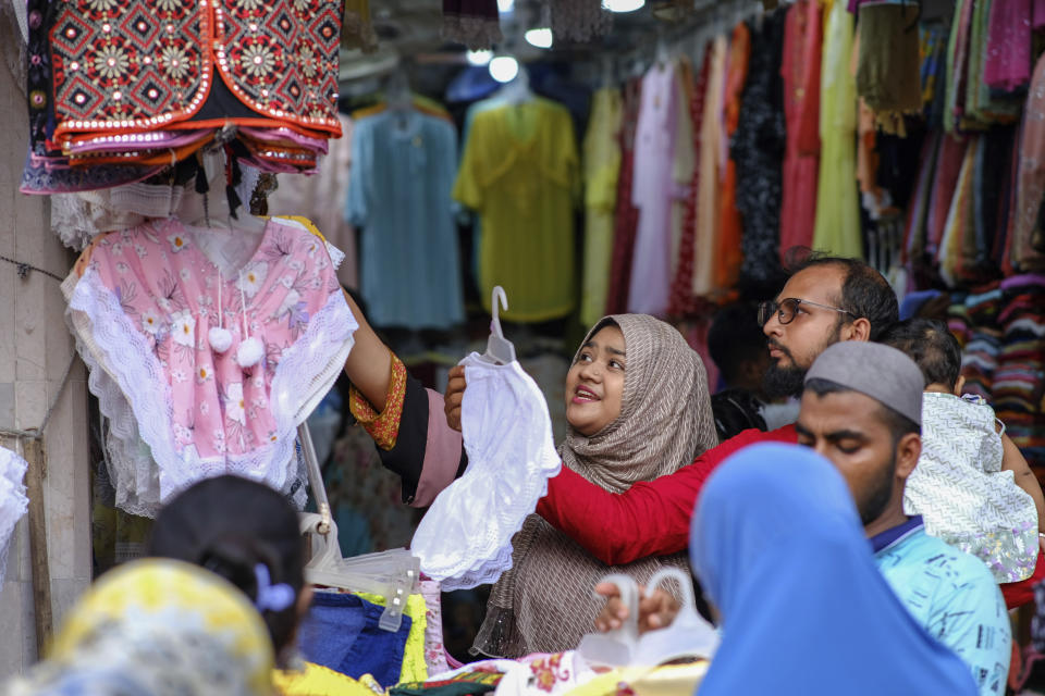 FILE - People shop at a market in Dhaka, Bangladesh, Friday, July 16, 2021. Bangladesh's economic miracle is under severe strain as fuel price hikes amplify public frustrations over rising costs for food and other necessities. (AP Photo/Mahmud Hossain Opu, File)