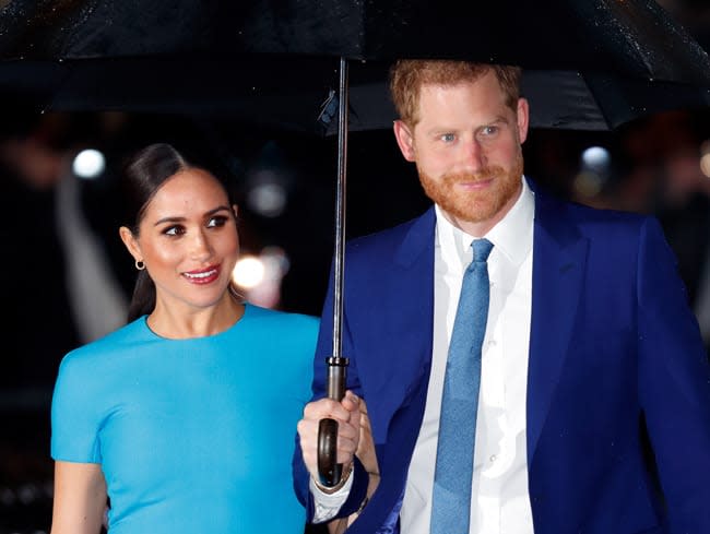 meghan smiles next to harry in small gold hoop earrings 