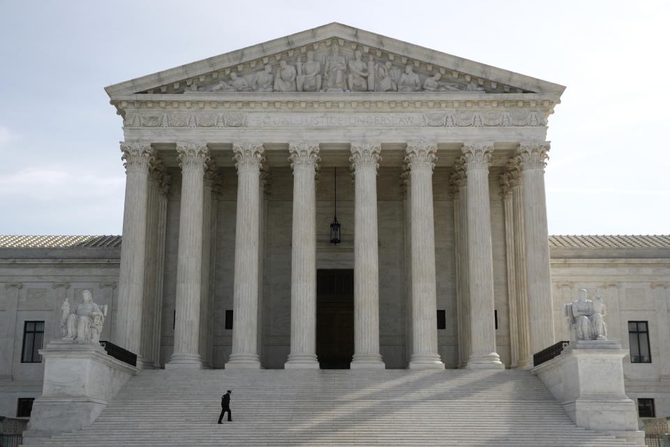 A police officer walks outside the Supreme Court in Washington, Monday, March 16, 2020. The Supreme Court announced Monday that it is postponing arguments for late March and early April because of the coronavirus, including fights over subpoenas for President Donald Trump's financial records. (AP Photo/Patrick Semansky)