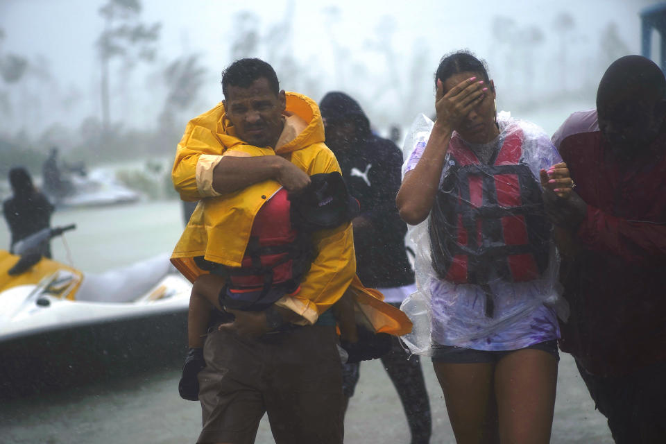 A family with a small child is escorted to a safety zone amid flooding in Freeport on Tuesday.