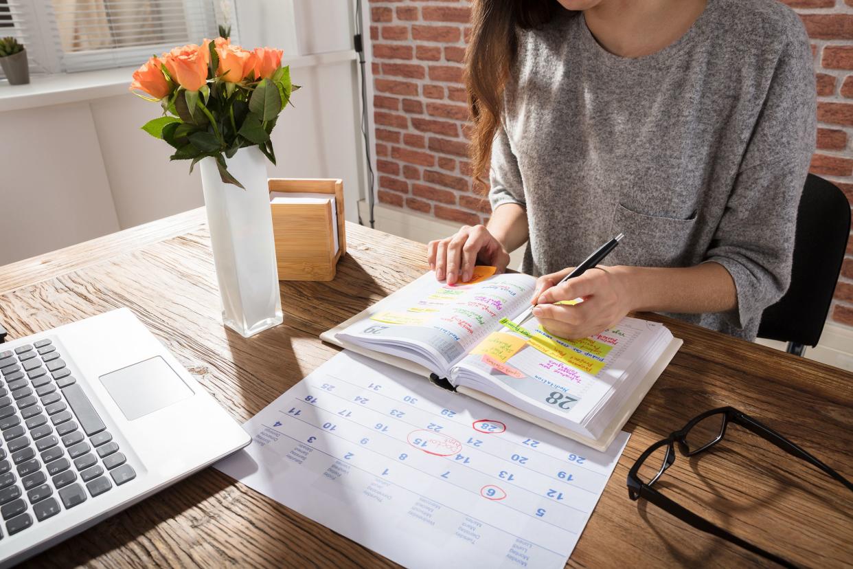 businesswoman making schedule on personal organizer