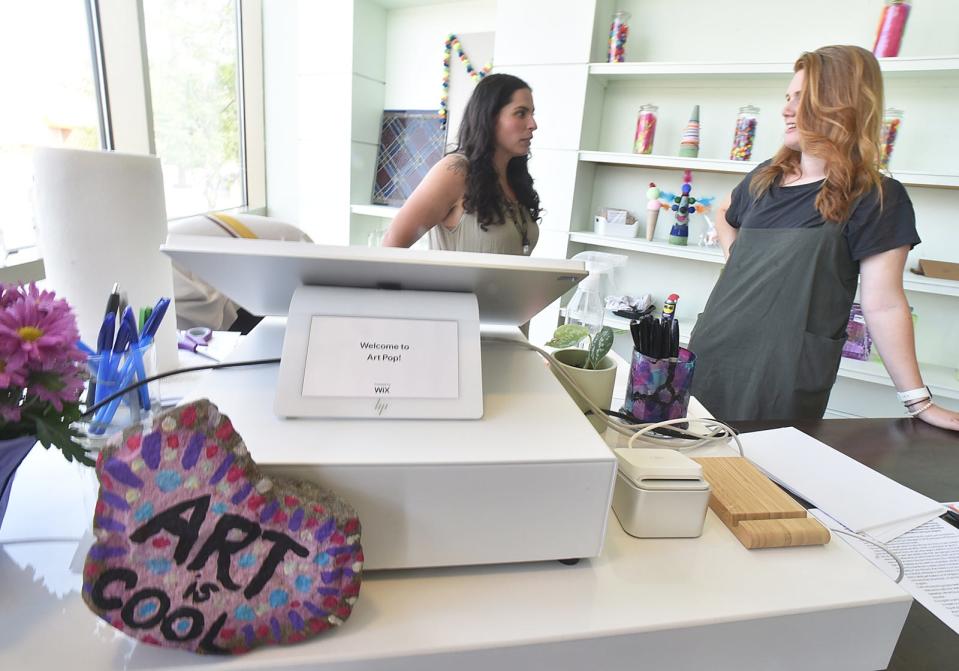 Art teacher Kayla Mateus and Art Pop co-founder Allison Faunce at the front desk.