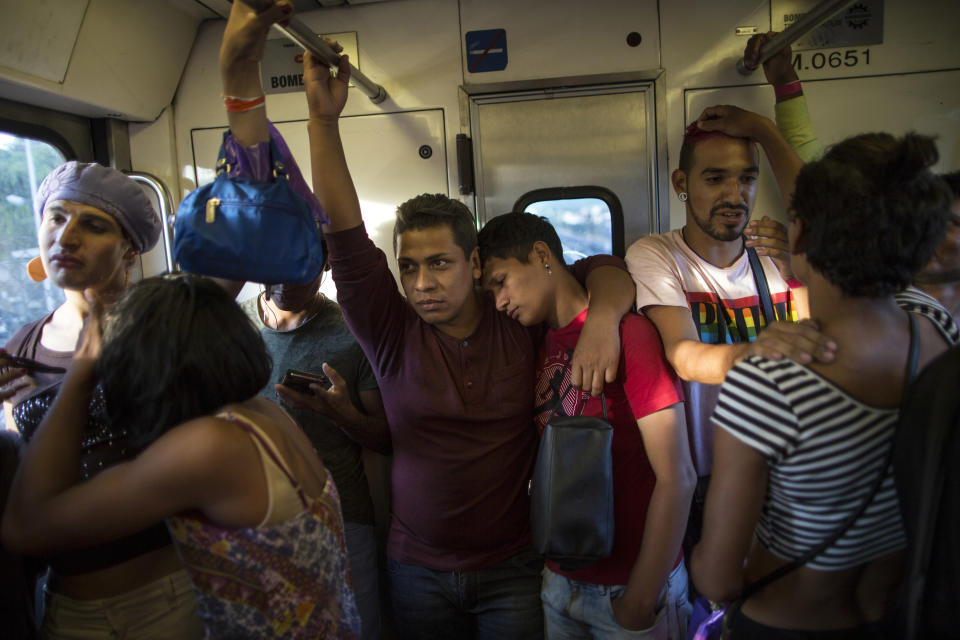 In this Nov. 8, 2018 photo, members of a group of 50 or so LGBTQ migrants traveling with the migrant caravan hoping to reach the U.S. border, ride the subway during a rest day, to the historic center in Mexico City. For the dozens of transgender women and gay men, the journey has meant putting up with insulting catcalls and even some physical abuse. (AP Photo/Rodrigo Abd)
