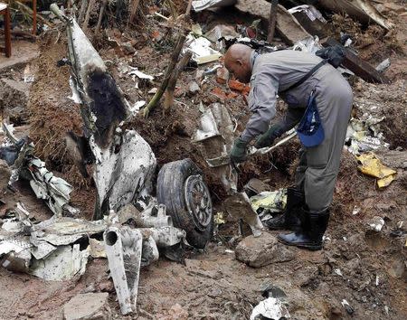 A member of the air force surveys the wreckage of the crashed private jet which was carrying presidential candidate Eduardo Campos, in Santos August 14, 2014. REUTERS/Paulo Whitaker