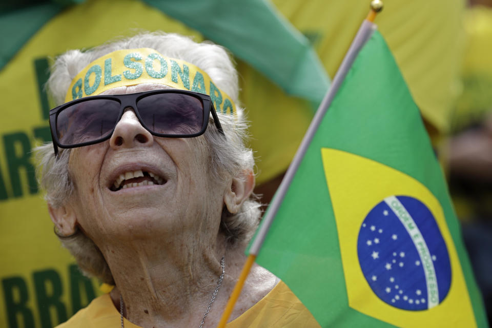 A supporter of Brazil's President Jair Bolsonaro attends a pro-government rally on Copacabana beach in Rio de Janeiro, Brazil, Sunday, May 26, 2019. The pro-Bolsonaro rally follows anti-government protests against cuts in the education budget as the president also battles an uncooperative Congress, a family corruption scandal and falling approval ratings after five months in office. (AP Photo/Silvia Izquierdo)