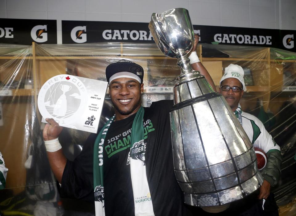 The Saskatchewan Roughriders Kory Sheets holds up the Grey Cup and his MVP trophy after they defeated the Hamilton Tiger-Cats in the CFL's 101st Grey Cup championship football game in Regina, Saskatchewan November 24, 2013. REUTERS/Mark Blinch (CANADA - Tags: SPORT FOOTBALL)