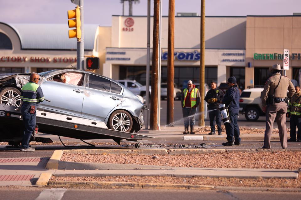 Crews remove a car involved in human smuggling following a deadly crash on March 17 on North Mesa Street near Pitt Street in West El Paso.