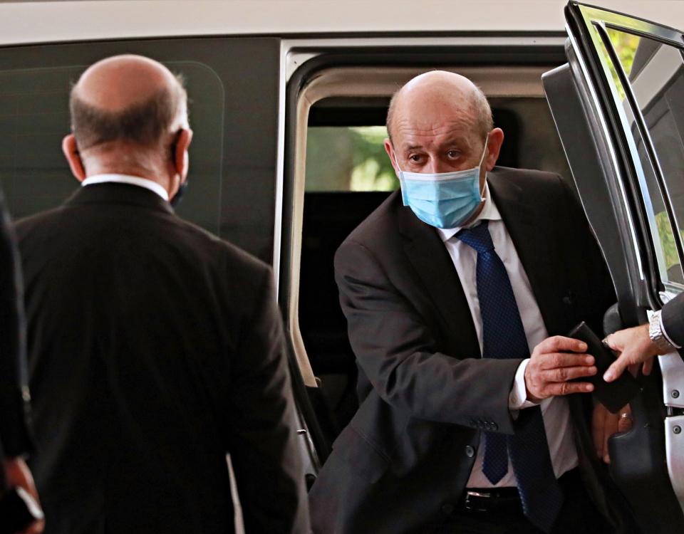 French Foreign Minister Jean-Yves Le Drian, right, wearing a mask to help prevent the spread of the coronavirus, arrives to meet his Iraqi counterpart Fouad Hussein, left, in Baghdad, Iraq, Thursday, July 16, 2020. (AP Photo/Hadi Mizban)