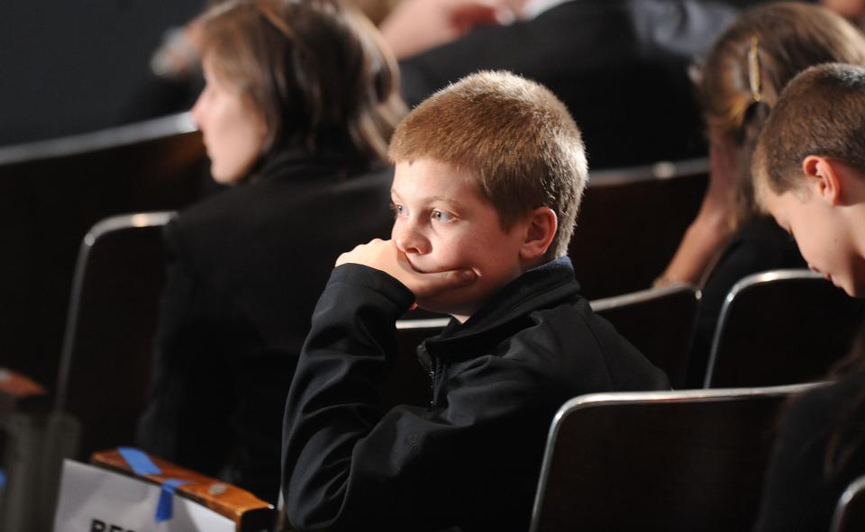 NEWTOWN, CT - DECEMBER 16: A young boy waits for U.S. President Barack Obama to speak at an interfaith vigil for the shooting victims from Sandy Hook Elementary School on December 16, 2012 at Newtown High School in Newtown, Connecticut. Twenty-six people were shot dead, including twenty children, after a gunman identified as Adam Lanza opened fire at Sandy Hook Elementary School. Lanza also reportedly had committed suicide at the scene. A 28th person, believed to be Nancy Lanza, found dead in a house in town, was also believed to have been shot by Adam Lanza. (Photo by Olivier Douliery-Pool/Getty Images)