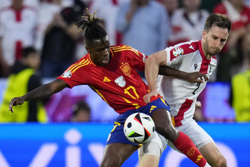 Georgia's Otar Kakabadze, right, challenges Spain's Nico Williams during a round of sixteen match between Spain and Georgia at the Euro 2024 soccer tournament in Cologne, Germany, Sunday, June 30, 2024. (AP Photo/Manu Fernandez)