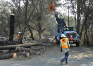 FILE - In this Oct. 18, 2017 file photo, a Pacific Gas & Electric crew work on replacing poles in Glen Ellen, Calif. Facing potentially colossal liabilities over deadly California wildfires, PG&E will file for bankruptcy protection. The announcement Monday, Jan. 14, 2019, follows the resignation of the power company's chief executive. (AP Photo/Ben Margot, File)