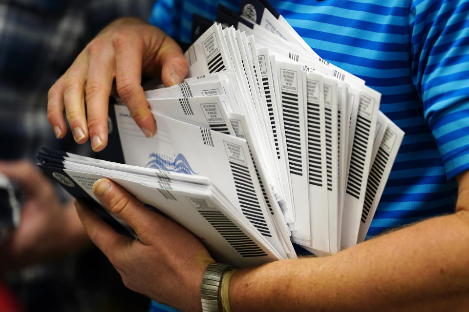 FILE - Kyle Hallman, with Chester County Voter Services, organizes mail-in ballots to be sorted for the 2020 General Election Oct. 23, 2020, in West Chester, Pa. Republicans are challenging extended mail ballot deadlines in at least two states in a move that could have severe implications for mail voting nationwide ahead of this year's presidential election. A lawsuit filed last week in Mississippi follows a similar one last year in North Dakota, both brought in heavily Republican states before conservative federal courts. (AP Photo/Matt Slocum, File)