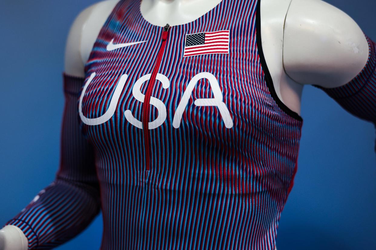 A close up of a red white and blue striped tank top with a red zipper and matching arm bands on a mannequin