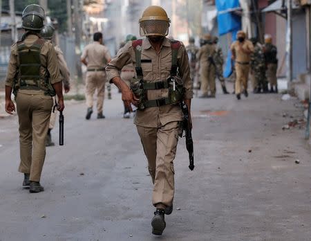 A policeman runs during a protest in Srinagar against the recent killings in Kashmir, July 18, 2016. REUTERS/Danish Ismail