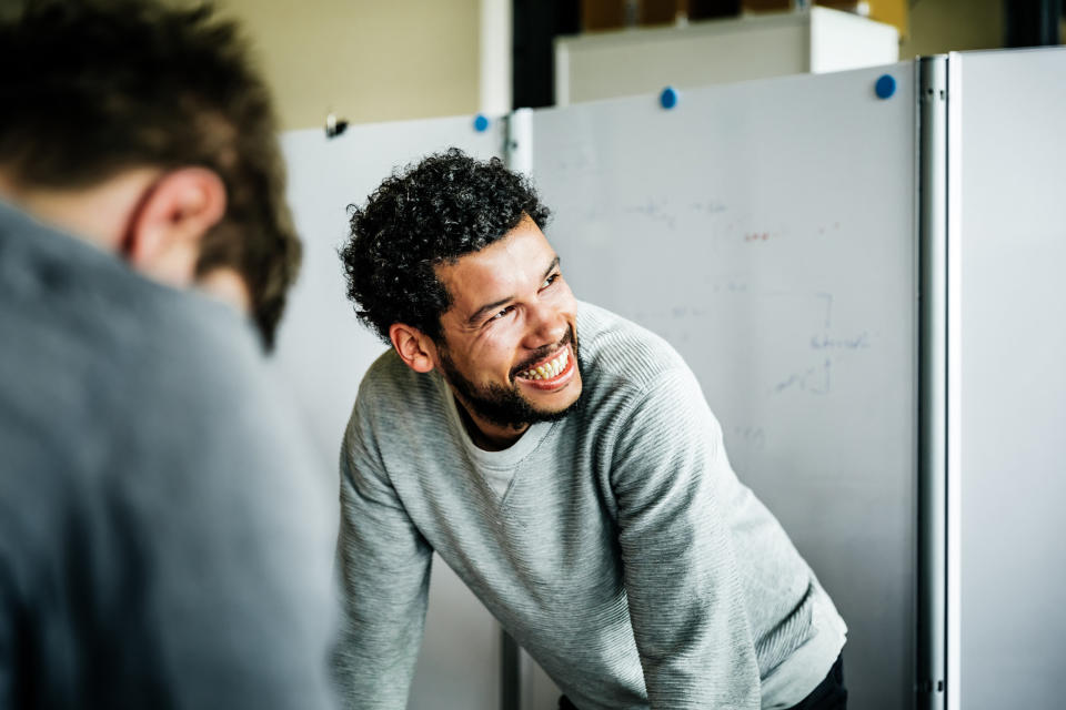 Someone smiles while at work, clearly having a good day