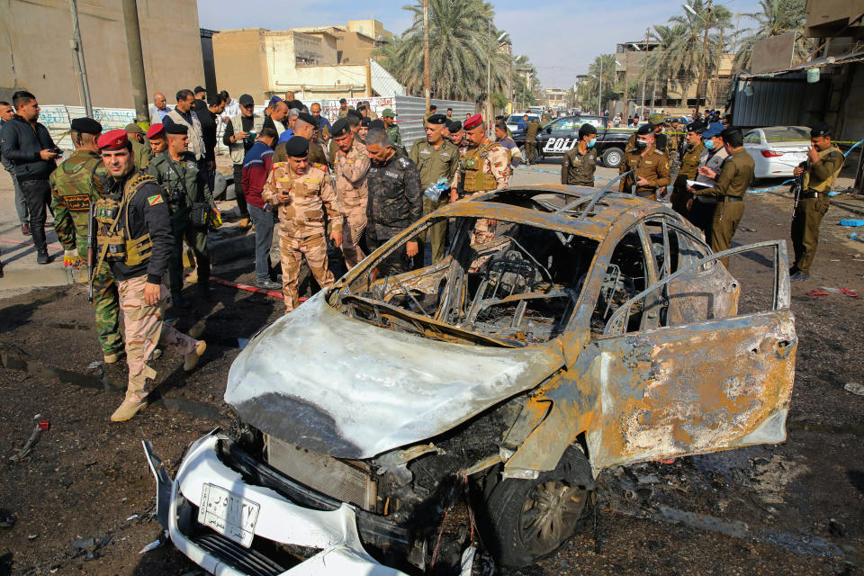 Iraqi security forces inspect the site of an explosion in Basra, Iraq, Tuesday, Dec. 7, 2021. The explosion rocked the center of Iraq’s southern city of Basra, killing at least four people and wounding several others. Local news reports initially reported a car bomb, but the governor of Basra told reporters on the scene that a motorcycle had exploded. (AP Photo/Nabil al-Jurani)