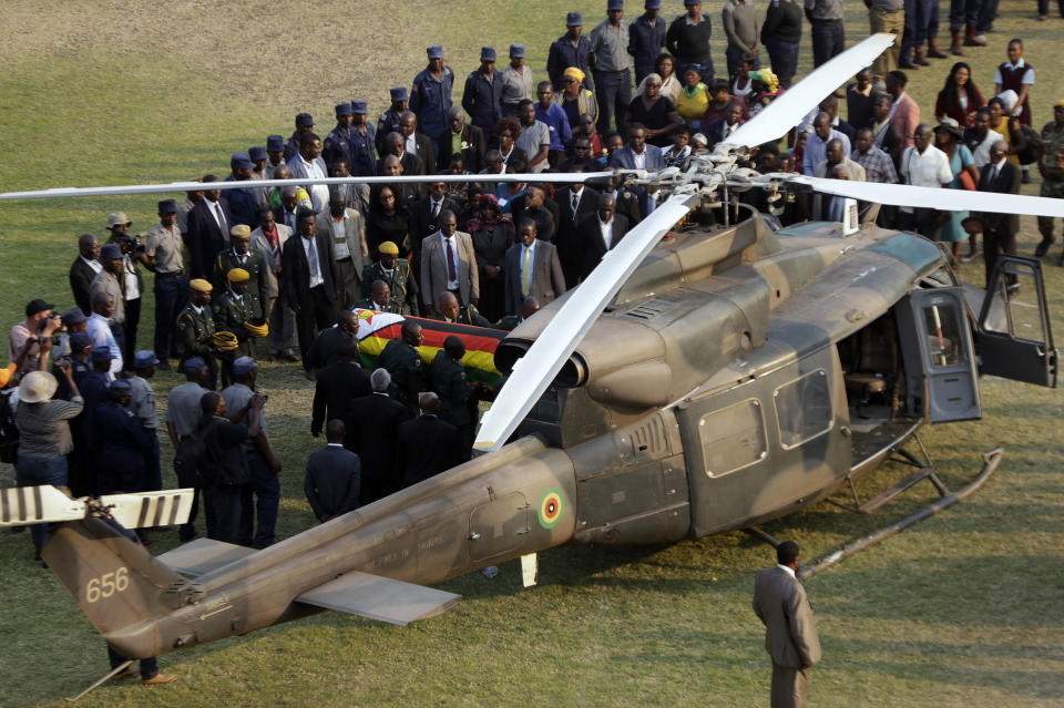 The coffin of former Zimbabwean President Robert Mugabe is carried to an awaiting helicopter to be flown back to the family residence after laying in state at the Rufaro Stadium in Harare Friday, Sept. 13, 2019. A family spokesman says Mugabe will be buried at the national Heroes' Acre site but it is not yet clear when. (AP Photo/Themba Hadebe)