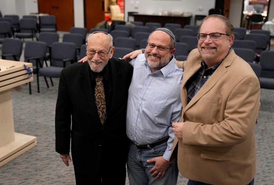 In this Dec. 22, 2022, photo, Lawrence Schwartz, left, Shane Woodward, center, and Jeff Cohen, right, smile as they pose for a photo inside Congregation Beth Israel in Colleyville, Texas. A year ago, rabbi Charlie Cytron-Walker and the three other men survived a hostage standoff at their synagogue in Colleyville, Texas. Their trauma did not disappear, though, with the FBI’s killing of the pistol-wielding captor. Healing from the Jan. 15, 2022, ordeal is ongoing.