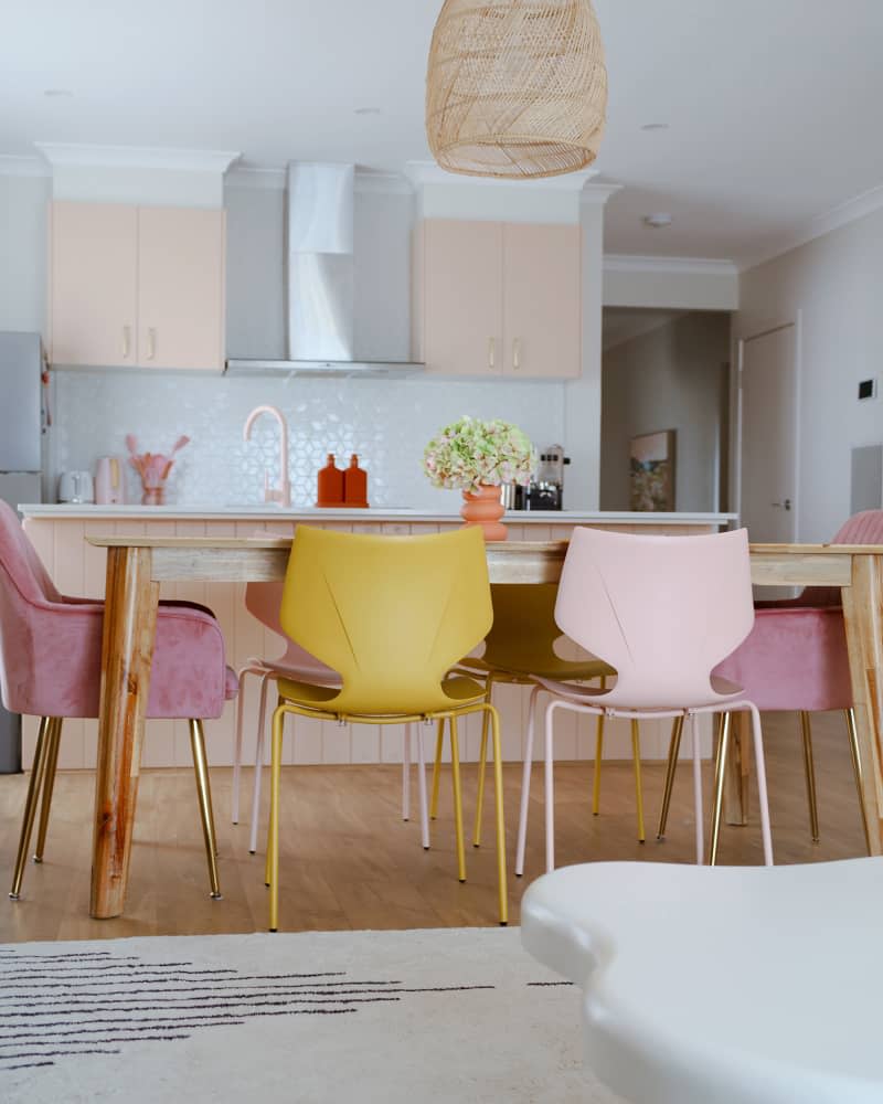 Colorful dining chairs around newly renovated dining and kitchen area.