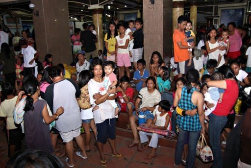 Residents gather at the provincial capital building in Tandag City, Surigao Del Sur Province, in the southern island of Mindanao on August 31, 2012. Families returned to their quake-devastated homes in the central Philippines Sunday, ignoring government warnings to relocate away from danger zones