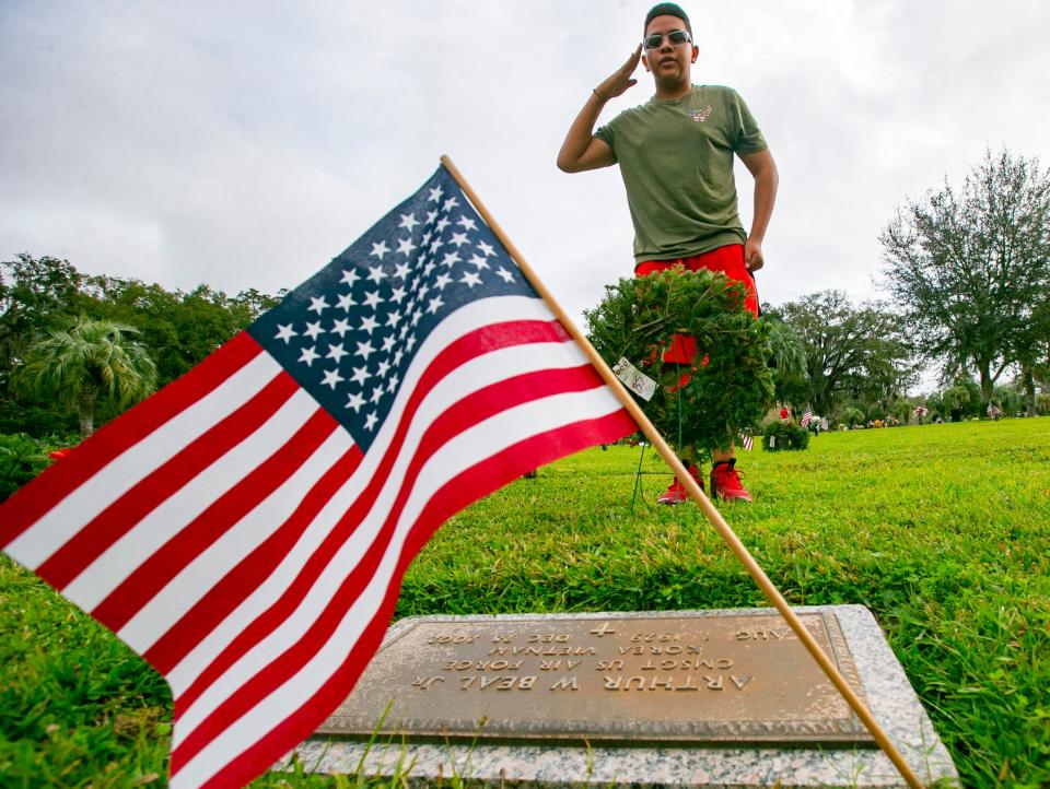 Forest High School Air Force Junior ROTC member Marcus Richardson salutes the grave of Vietnam and Korean War Air Force veteran Arthur Beal Jr. after placing a wreath on his grave as part of the national Wreaths Across America Day on Dec. 19, 2021.