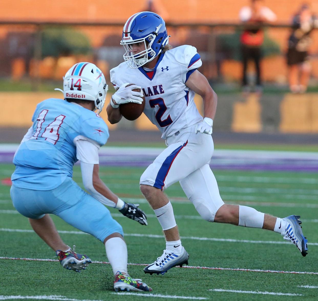 Nathan Baker, 2, of Lake runs past Carter Bugara, 14, of Alliance for a big gain during their game at Alliance on Friday, August 19, 2022.