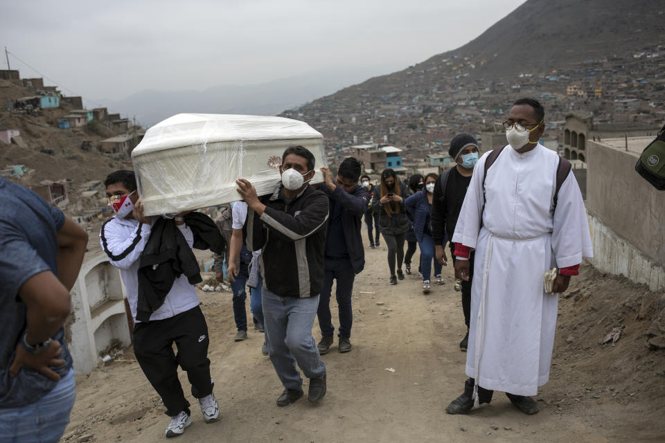 El hermano Ronald Marín, un laico de 30 años de Venezuela, acompaña a un lugar de enterramiento a los familiares de Juan Tito Ramos, de 87 años, que murió de coronavirus, en el cementerio "Mártires 19 de Julio" en Comas , en las afueras de Lima, Perú, el lunes 6 de julio de 2020. Perú tiene la tasa de mortalidad COVID-19 más alta por millón en las Américas, por encima de Chile, Estados Unidos, Brasil y México. (AP Foto/Rodrigo Abd)