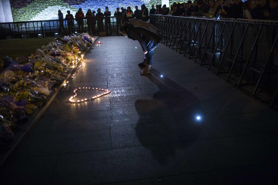 People bow during a memorial ceremony for people who were killed in a stampede incident during a New Year's celebration on the Bund, in Shanghai