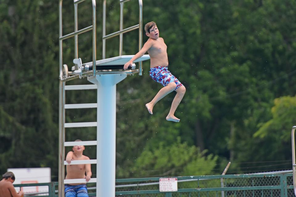 Nykkelis Zornes spins as he jumps off the diving board at Aumiller Park Pool during the summer of 2021. The pools is taking applications for summer staffing.