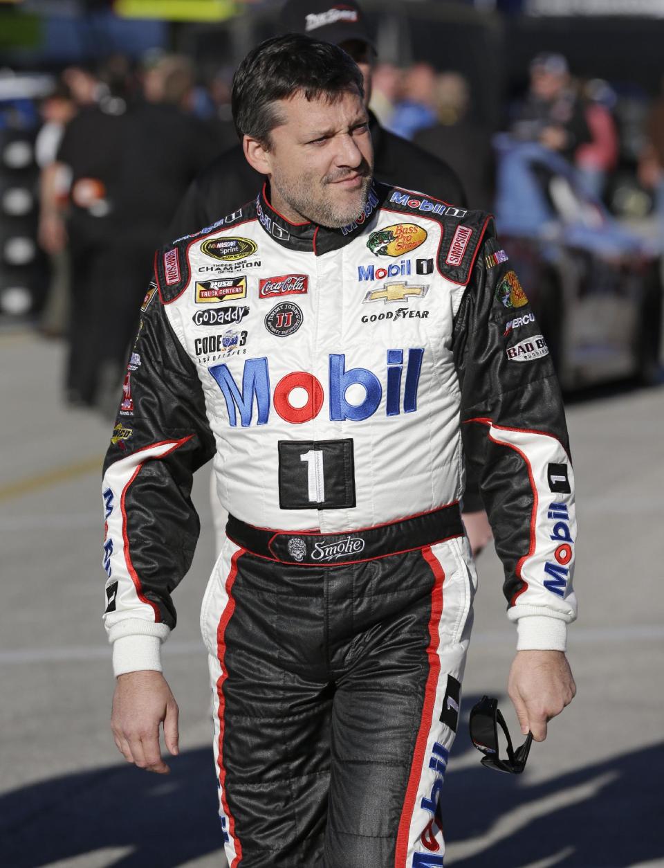 Tony Stewart walks to his garage before practice for the Sprint Unlimited auto race at Daytona International Speedway in Daytona Beach, Fla., Friday, Feb. 14, 2014. Stewart has not raced in more than six months since he broke two bones in his leg in an August sprint-car crash.(AP Photo/John Raoux)