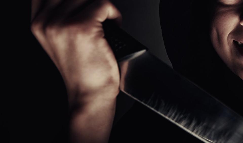 Extreme close up of boy's hand holding a large knife