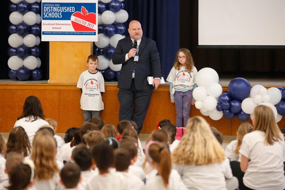 Massachusetts Commissioner of Elementary and Secondary Education Jeffrey Riley is flanked by two volunteer students to celebrate the Acushnet Elementary School being designated a National ESEA Distinguished School.