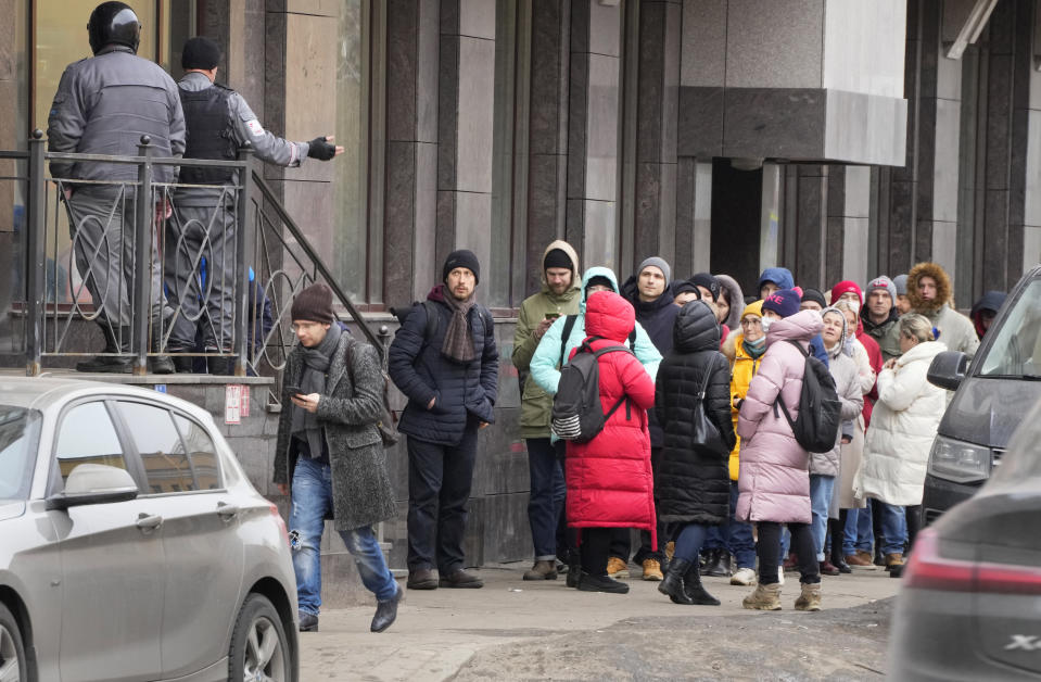 People stand in line to withdraw U.S. dollars and Euros from an ATM in St. Petersburg, Russia, Friday, Feb. 25, 2022. Ordinary Russians faced the prospect of higher prices and crimped foreign travel as Western sanctions over the invasion of Ukraine sent the ruble plummeting, leading uneasy people to line up at banks and ATMs on Monday in a country that has seen more than one currency disaster in the post-Soviet era. (AP Photo/Dmitri Lovetsky)