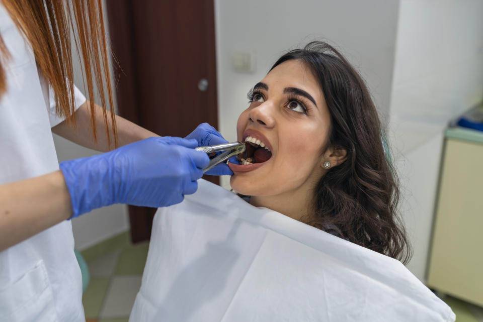 Dentist about to pull out a patient's tooth