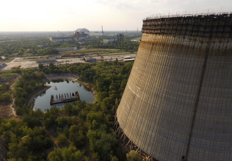 A partially-constructed and abandoned cooling tower stands over the enclosure built over stricken reactor number four (Getty Images)