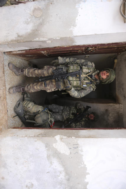 Turkish soldiers stand in a house in the countryside in the Syrian province of Idlib, Monday, Feb. 10, 2020. Turkey said it hit back at Syrian government forces on Monday, after "intense" Syrian shelling killed five of its soldiers and wounded five others in Syria's northern Idlib province. (AP Photo/Ghaith Alsayed)