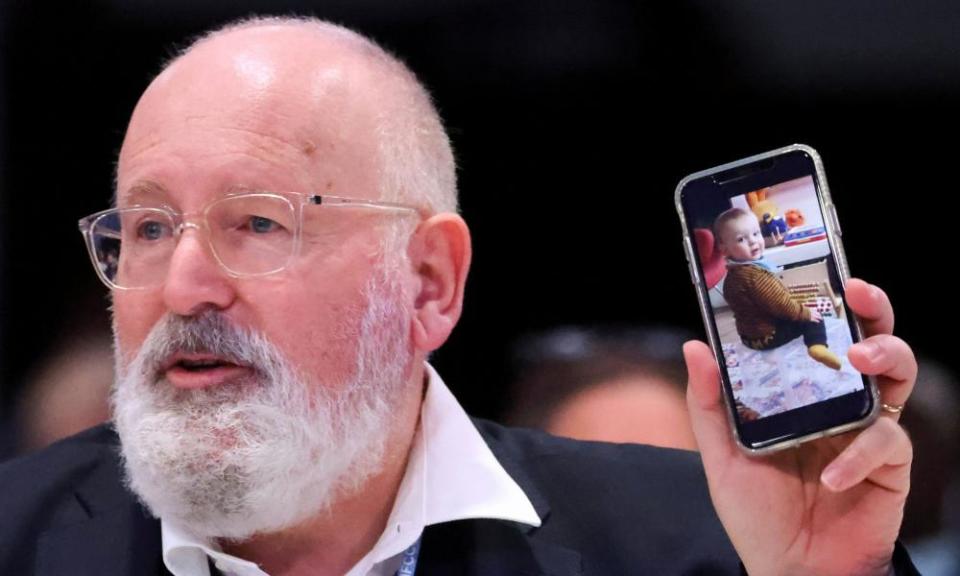 Frans Timmermans, vice-president of the European Commission, shows a picture of his one-year-old grandson, Kees, as he speaks at Cop26.