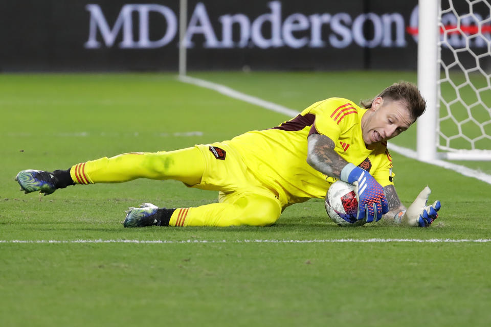 Houston Dynamo goalkeeper Steve Clark makes a save on a shot on goal by Sporting Kansas City during the first half of an MLS playoff soccer match, Sunday, Nov. 26, 2023, in Houston. (AP Photo/Michael Wyke)