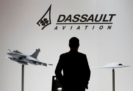 FILE PHOTO: A visitor looks at replicas of the fighter jet Rafale (L) and Neuron on the Dassault booth during the European Business Aviation Convention & Exhibition (EBACE) at Cointrin airport in Geneva, Switzerland, May 19, 2015. REUTERS/Denis Balibouse