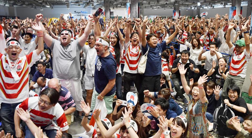 Japan team's fans celebrate the team's win over Scotland at the Rugby World Cup Pool A game as they watch the game in a public viewing in Tokyo, Sunday, Oct. 13, 2019. (Kyodo News via AP)