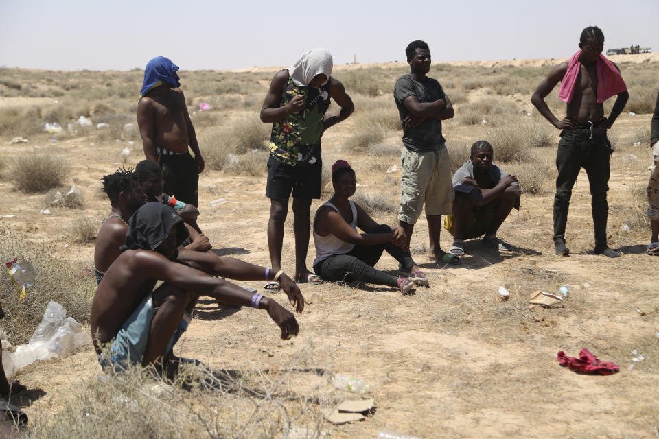 African migrants stand on the Libyan border with Tunisia on Thursday, Aug. 4, 2023. The Tunisian security forces reportedly expelled hundreds of migrants over the border into Libya, where they have been stranded in scorching summer temperatures without water and food since June. (AP Photo/Yousef Murad)
